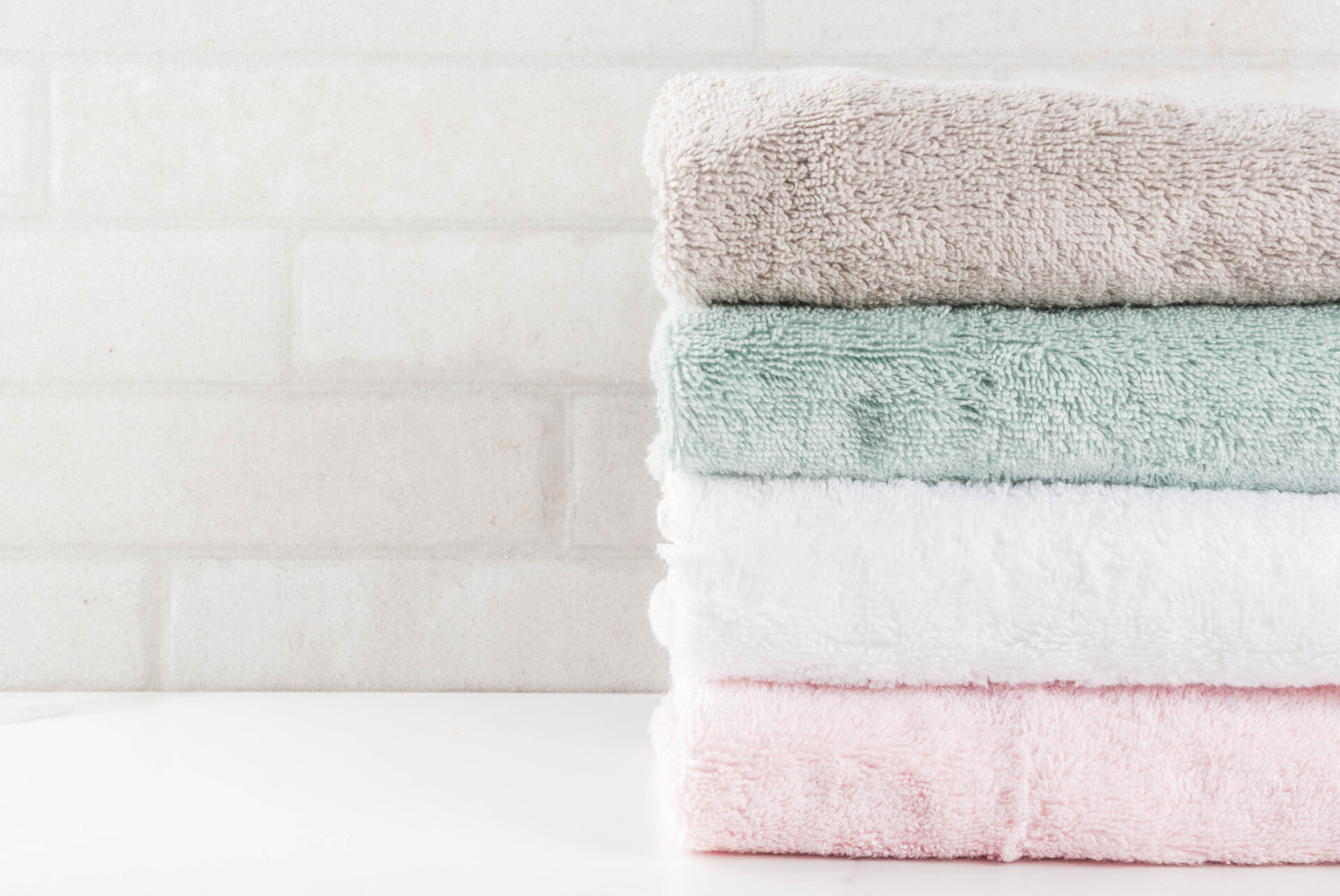 Badetücher, Handtücher, bunte Baumwoll-Frottee-Textilien im weißen Badezimmer